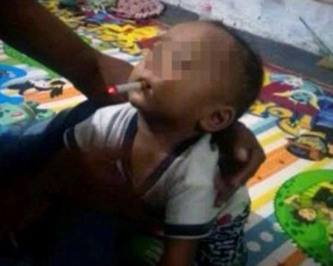 穆萨米尔把香烟放入儿子嘴里。 网上图片