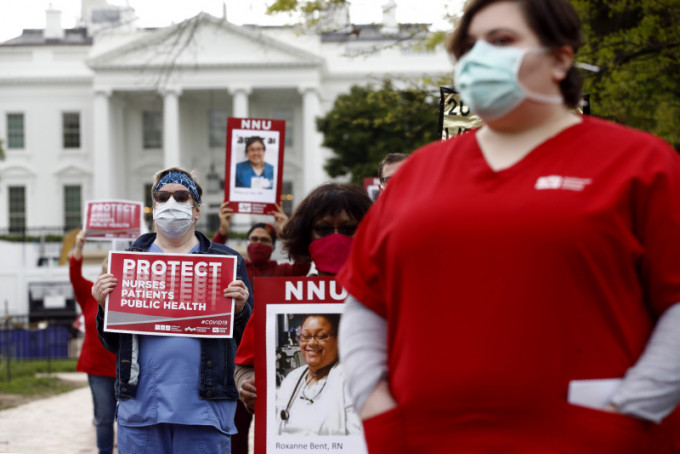 美国一批护士在白宫前手持逝世同事照片，抗议防护装备不足。AP图