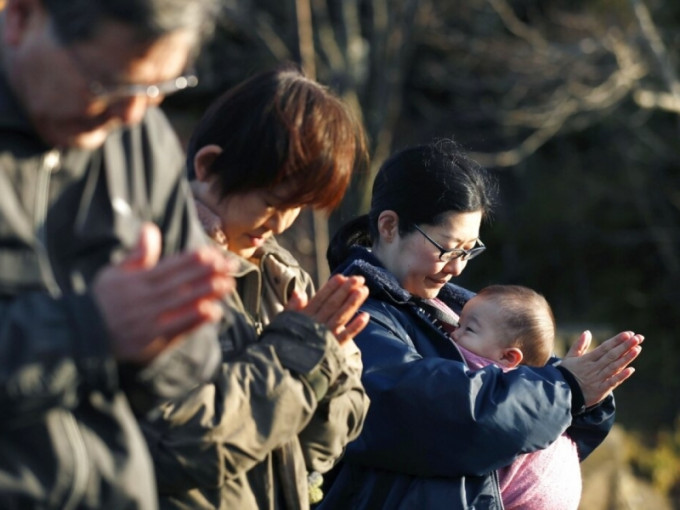 在宫城县石卷市，民众为「311大地震」的遇难者祈祷。AP
