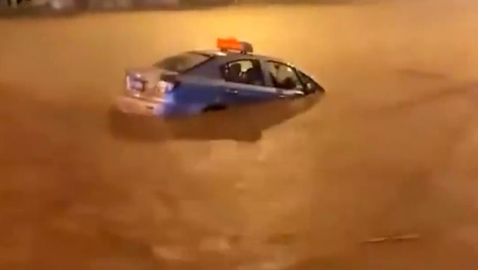 重慶部分地區水浸嚴重水深過腰，的士積水中漂浮，乘客趟水下車，水位沒過腰部。