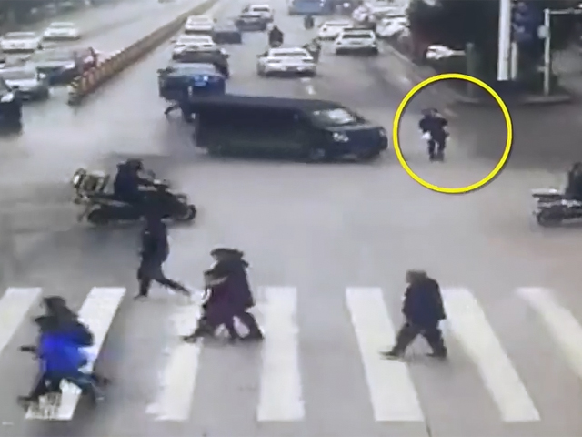 一名女子過馬路途中只顧低頭玩手機，完全無理會路面狀況，被一輛轉彎的私家車撞倒。   影片截圖