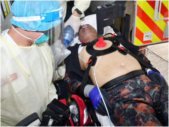 救援人员用自动心外压机为昏迷的事主急救。