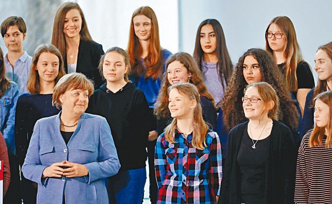 德国总理与一群女孩出席活动。