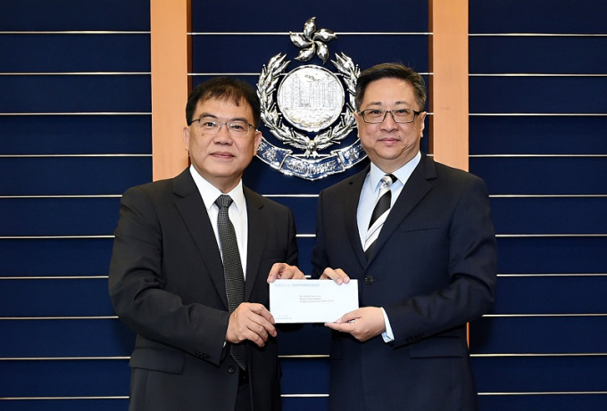 警務處處長盧偉聰（右）頒授委任狀予新任輔警副總監鄭文森（左）。香港警務署提供