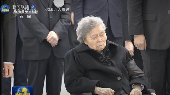 遗孀王冶坪轮椅亮相，神情哀伤。央视画面