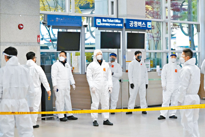 檢疫人員周三在南韓仁川國際機場等候旅客抵達。