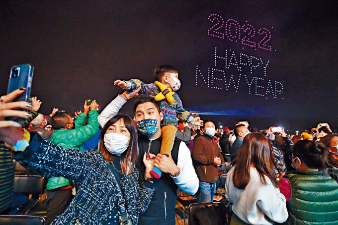■市民在无人机做出的二○二二年快乐新年庆祝字句下，打卡留住一家人一起跨年的美丽时刻。