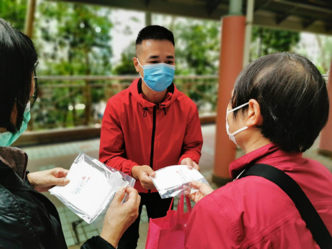 慈云山社区干事潘卓斌向居民派发抗疫物品。