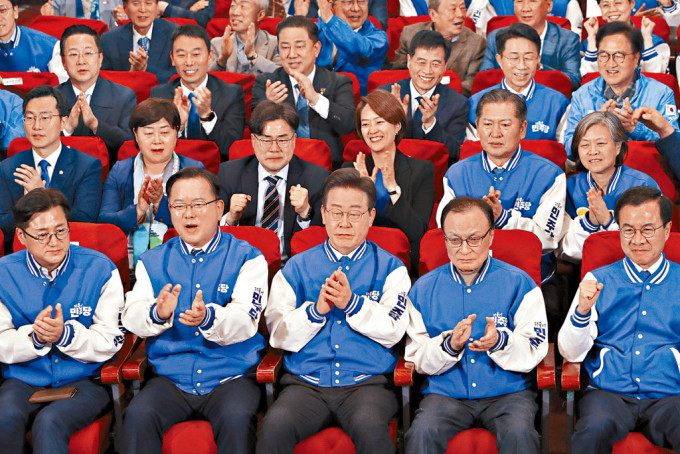 南韩在野共同民主党党魁李在明及一众候选人，周三在首尔观看电视播放票站调查结果。