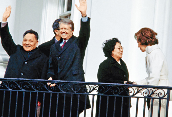 卡特與鄧小平1979年在白宮露台向民眾揮手，兩人的夫人在旁交談。