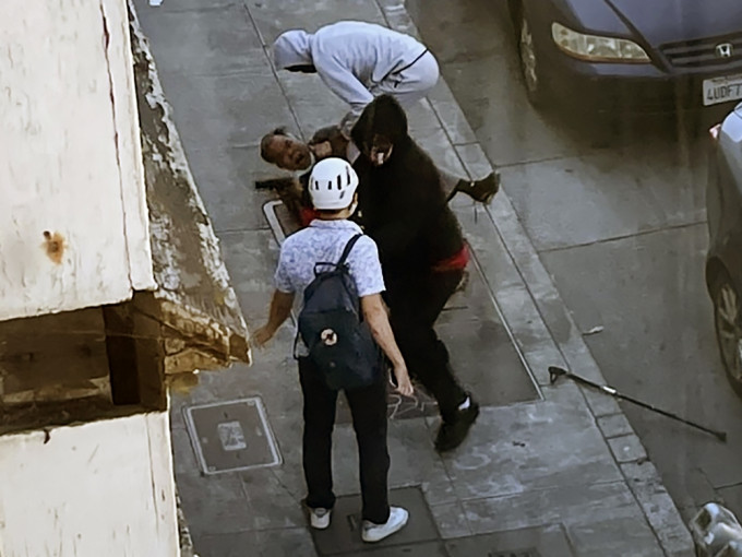 两名持枪歹徒在街上把一名亚裔老翁推跌在地上。AP相片