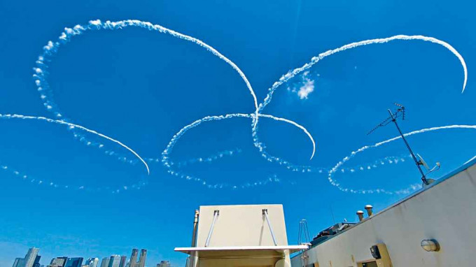 日本航空自衞队特技飞行队「蓝色冲击波」周三在东京市中心上空画出奥运五环。