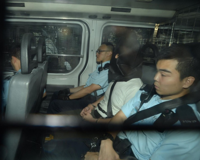 被告卢俊希被警员押上法庭。