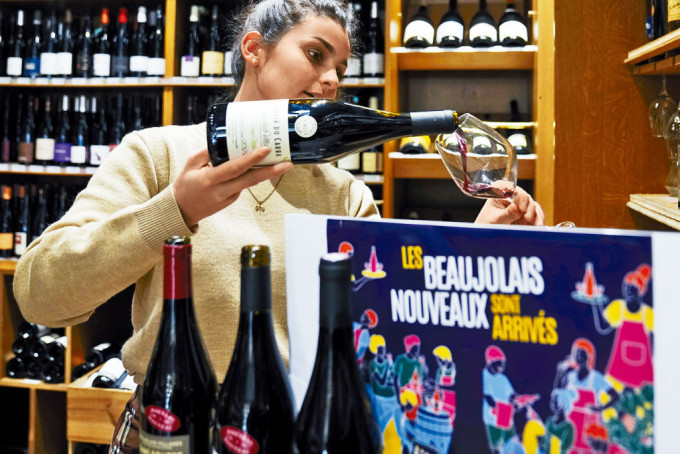 巴黎一間葡萄酒專賣店的員工，正在倒一杯葡萄酒。