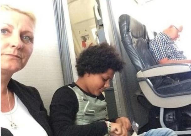 宝拉（左）和女儿被迫坐在机舱地板上。（网图）