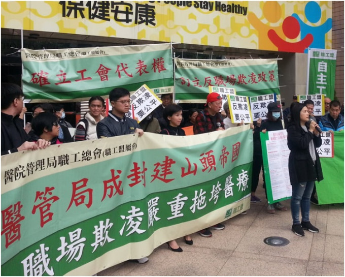 30多名医管局职工总会成员带同横额到医管局总部外抗议。