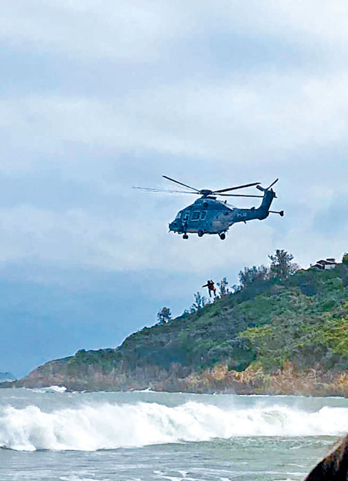 ■直升機吊下救援人員，營救被困洋漢及救生員。