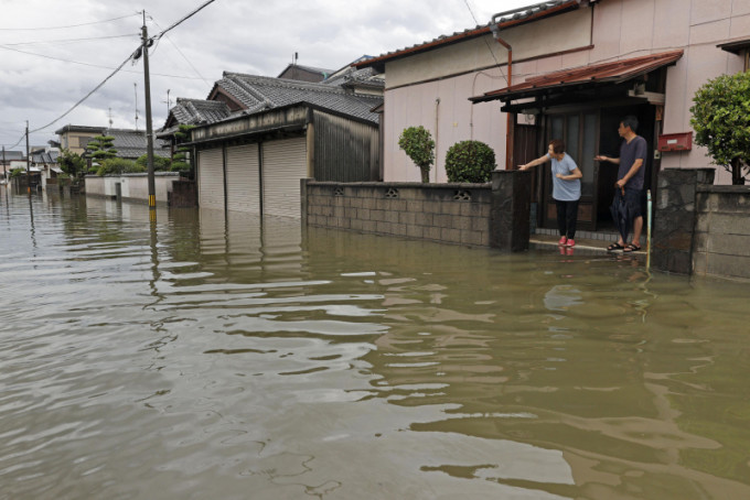 日本持續受暴雨侵襲，河流氾濫成災。AP圖