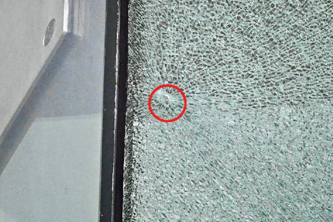 西九法院早前的玻璃幕墙疑被射击碎裂，修路工人在行车天桥加建4米高围栏。资料图片