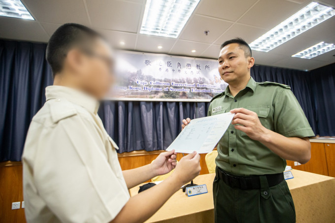 歌连臣角惩教所监督陈少恒（右）颁发成绩通知书予青少年在囚人士。政府新闻处