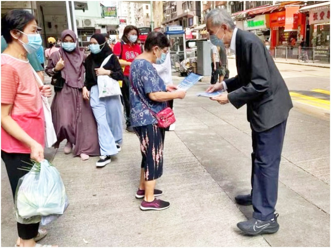 黃志祥（右）到石塘咀街市街站給市民派傳單。