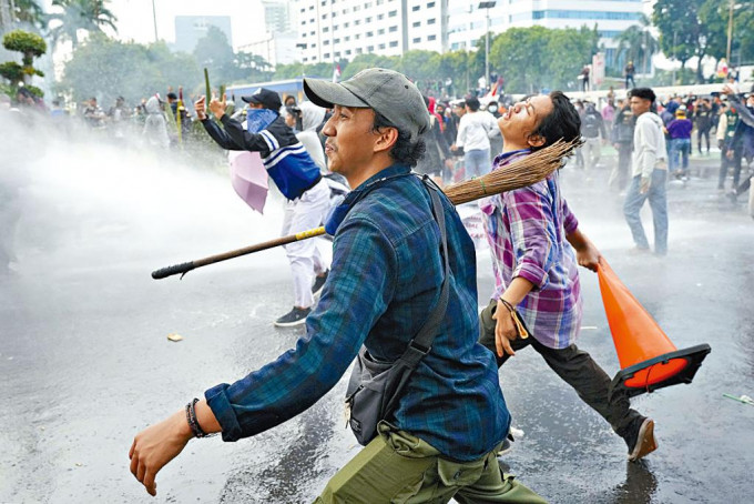 印尼示威学生在耶加达向防暴警察投掷杂物。