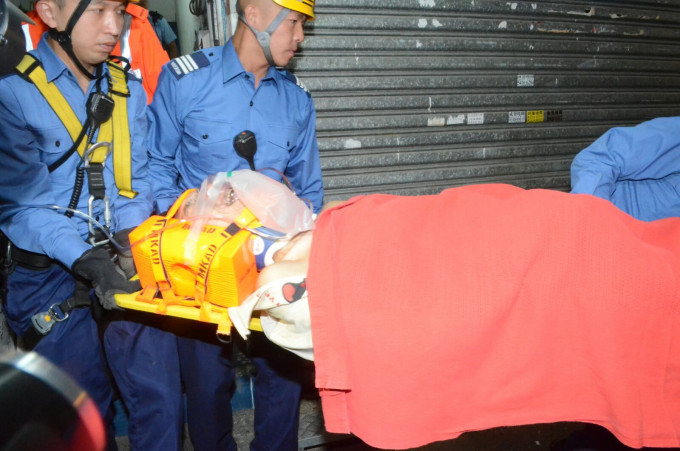 男子情绪激动不停呻吟，救护员要一边安抚他上救护车。