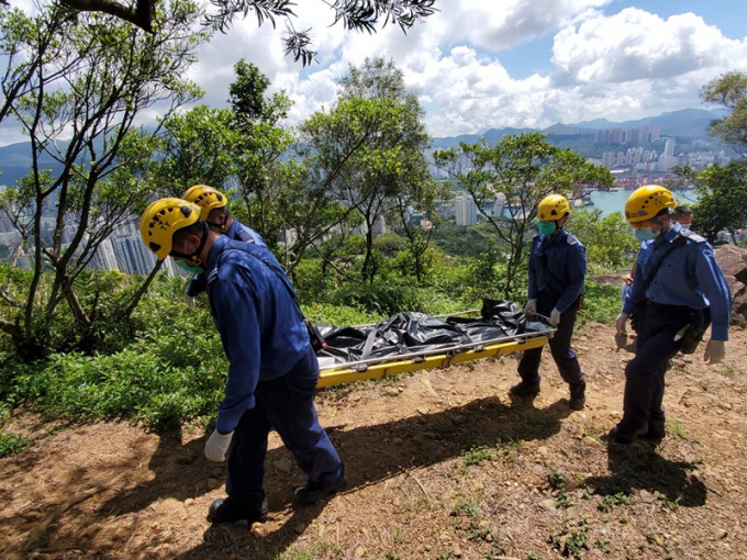 消防協助將男子遺體移往山腳。梁國峰攝