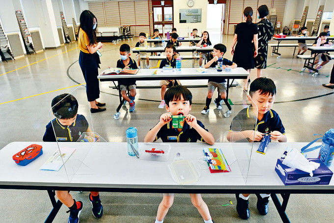劉平齋國際學校在長枱設擋板分隔學生，並在使用後即時清潔。