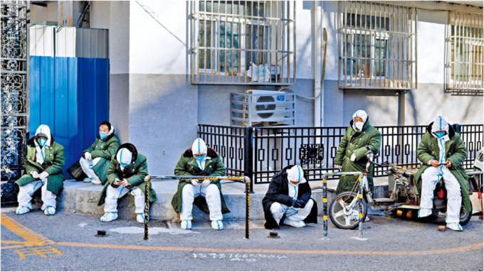 北京疫情持续，不少防疫人员在街头蹲坐休息。