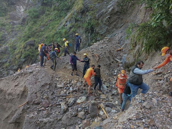 印度发生严重水灾并引发泥石流，救援人员协助民众离开。AP图