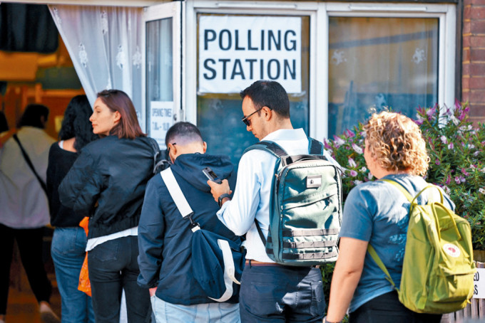 选民在伦敦一个票站外排队投票。