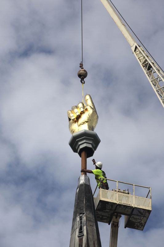 雕塑由起重机吊起。AP
