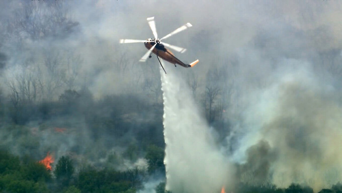 直升机协助扑救在德克萨斯州帕洛平托县的一场山火。AP