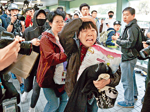 ■女遊人在行人天橋被示威者喝罵，嚇得抱着貨品急逃。