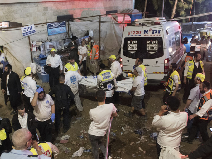以色列宗教活動人踩人至少38人死亡，急救人員遮蓋遇難者遺體送走。AP圖片