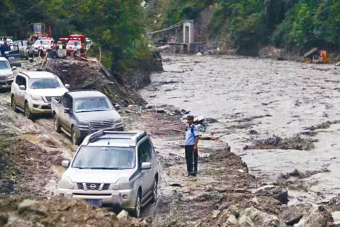 北川縣公安在臨時道路上疏導被困車輛。
