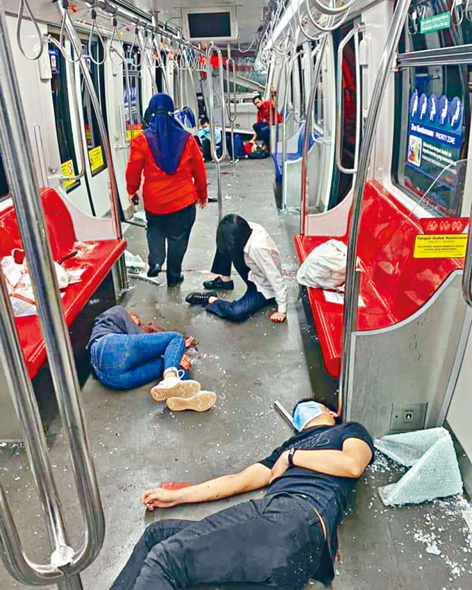 吉隆坡周一晚两列轻轨列车对撞，许多乘客在车厢内受伤倒地。一名妇人脚踝受伤（右）瑟缩一角。