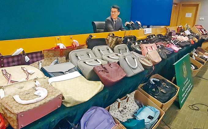 海关王志贤讲述案情，并展示检获的冒牌手袋及衣服等物品