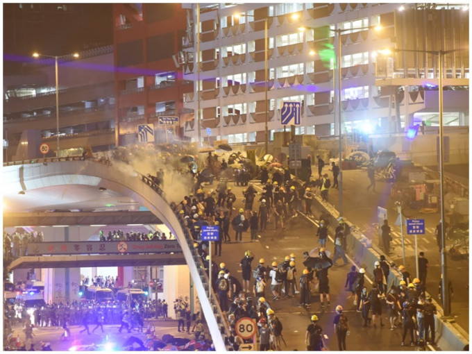 警方从停车场向天桥上的示威者发射催泪弹。