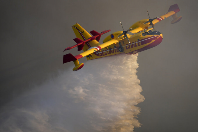 当局出动飞机洒水救火。AP图片