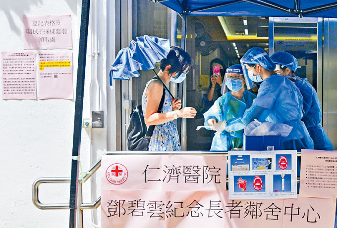 石硖尾邨内仁济医院邓碧云纪念长者邻舍中心外，市民领取咽喉拭子采样套装。
