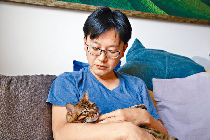 周英杰手抱蔡天鳳生前喜歡的貓兒懷念故人。