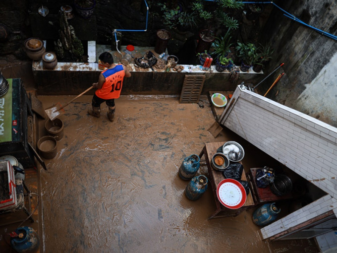 居民在正安縣碧峰鎮的家中清理積泥。新華社