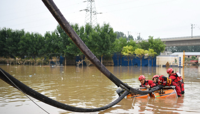 河北涿州消防員在災區排澇作業。