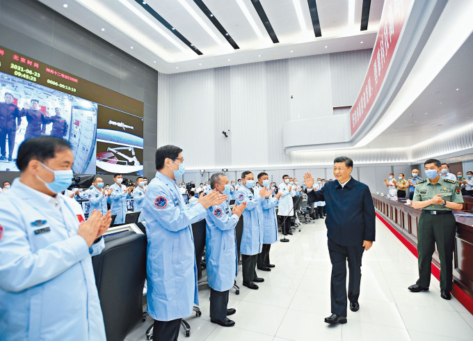 ■習近平向北京航天飛行控制中心的工作人員揮手。　