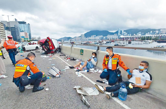 的士被跑車撞翻險墮橋，兩名傷者坐路肩待援。