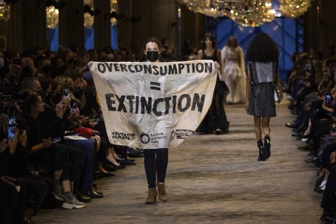 示威者手举「overconsumption = extinction」。美联社图片