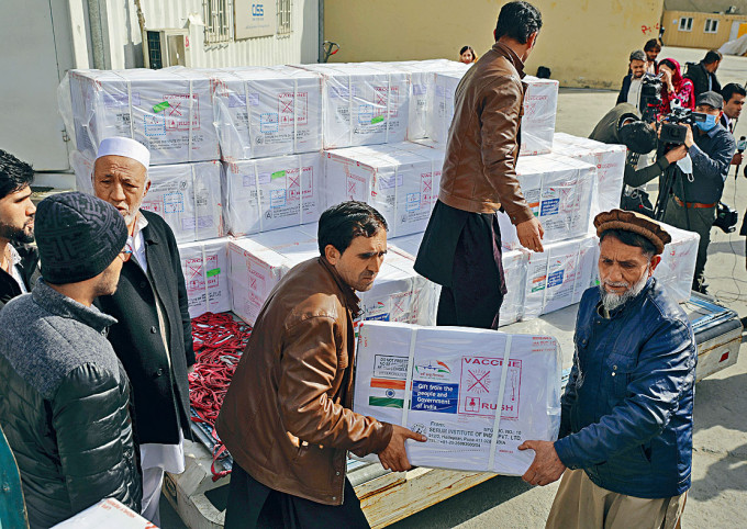 阿富汗生部的工人搬運首批由印度捐贈的五十萬劑牛津疫苗。