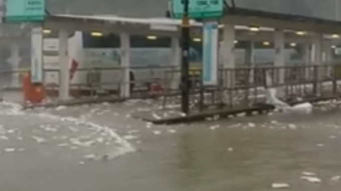 巨浪涌上数十米外的巴士总站。影片截图